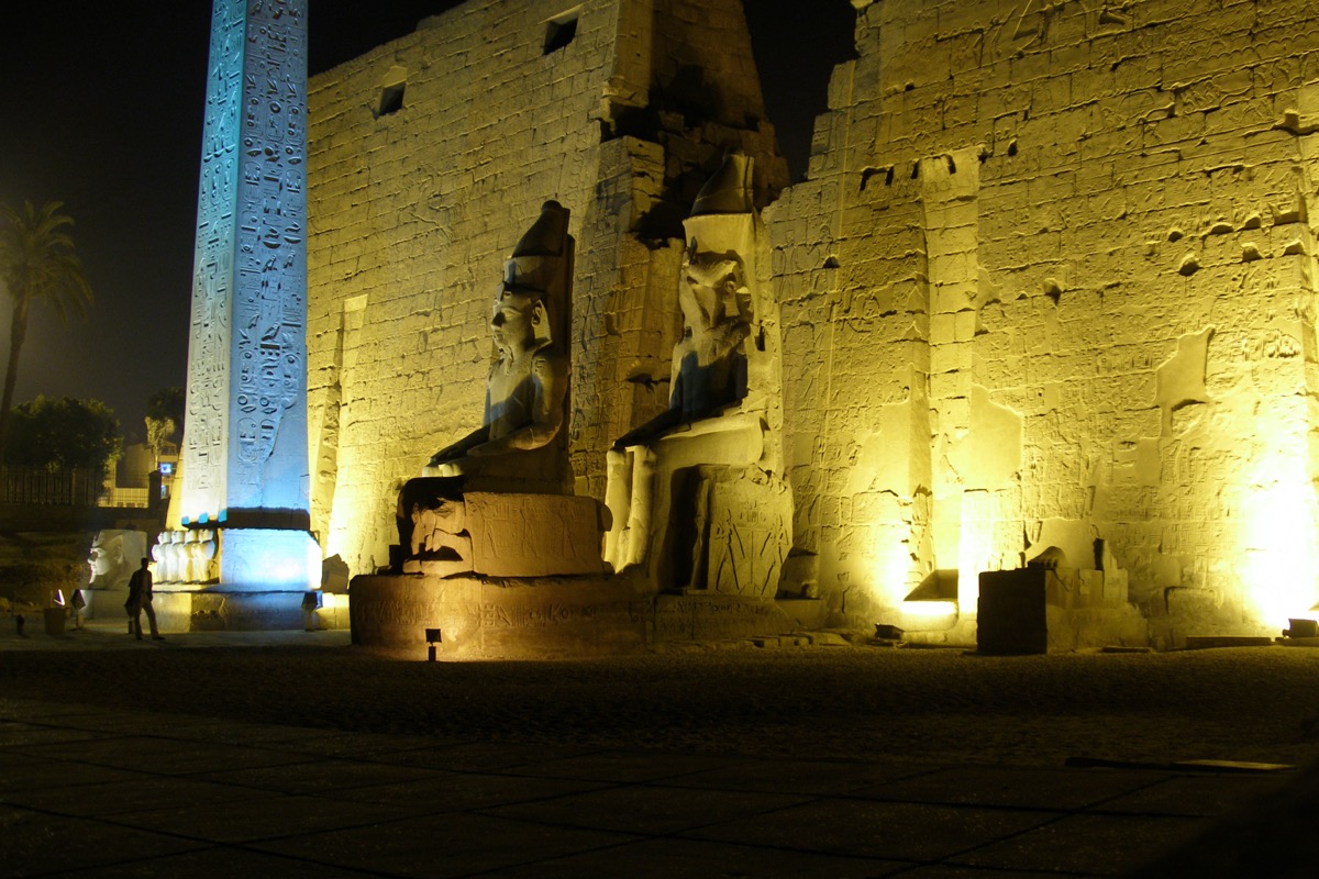 Luxor Temple illuminated at night, columns reflected in the forecourt paving